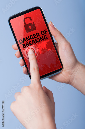 Man presses a touch screen smart phone with the symbol of danger