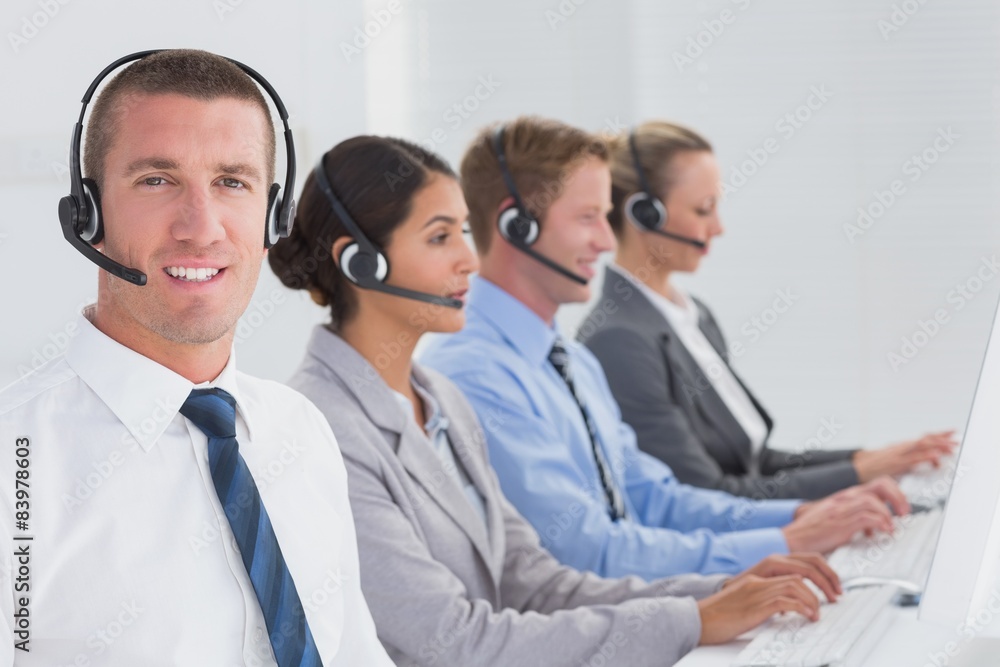Business team working on computers and wearing headsets Business team working on computers and wearing headsets
