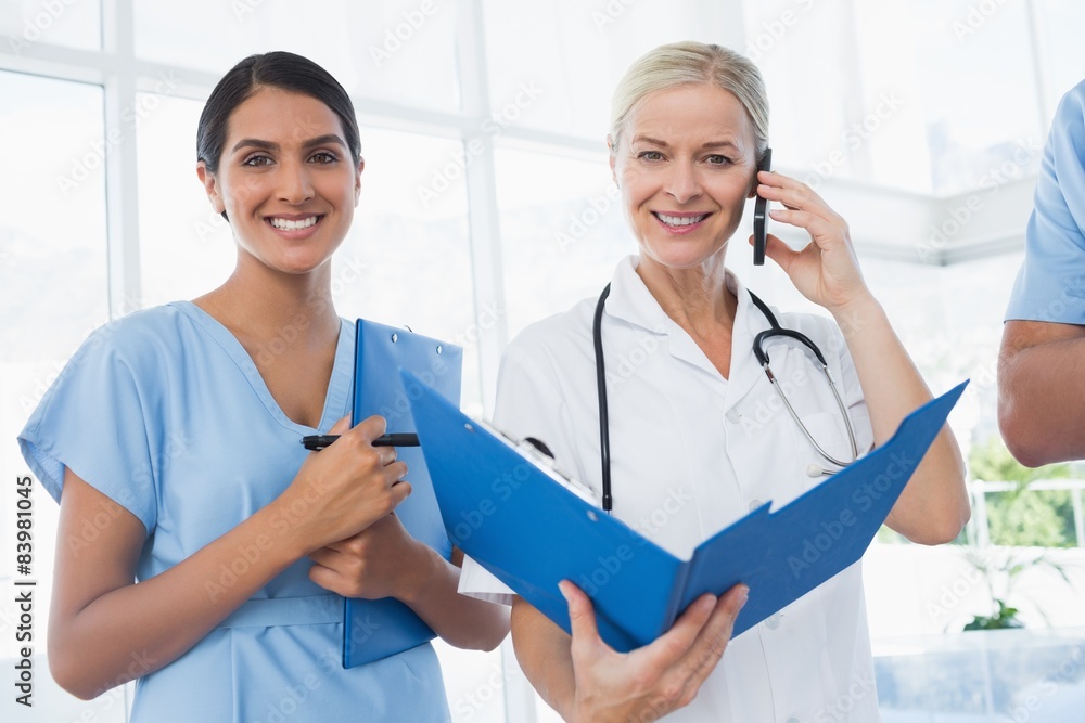 Doctor holding folder and having phone call Doctor holding folder and having phone call