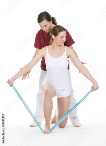 woman with physiotherapist reinforcing arms with rubber bands