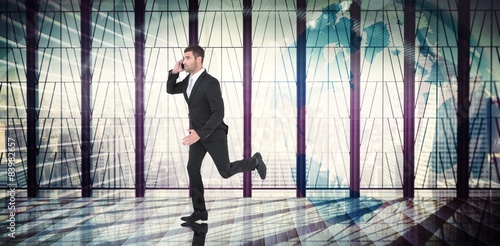 Composite image of businessman running on the phone 