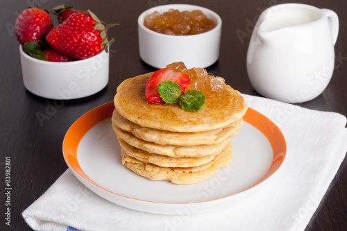 Delicious pancakes with fresh strawberries on a plate  jam and m