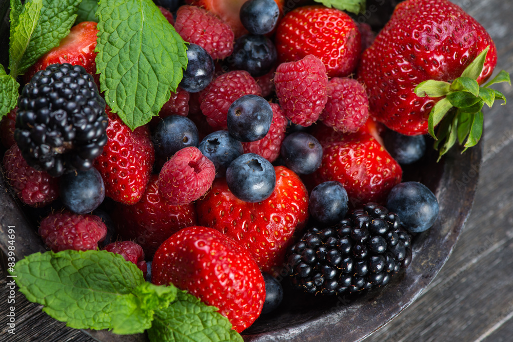 Fresh summer berries with mint in rustic bowl Fresh summer berries with mint in rustic bowl