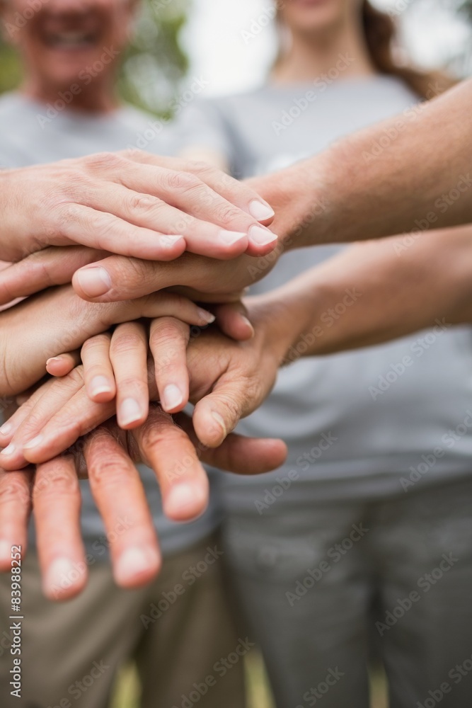 Happy volunteer family putting their hands together 