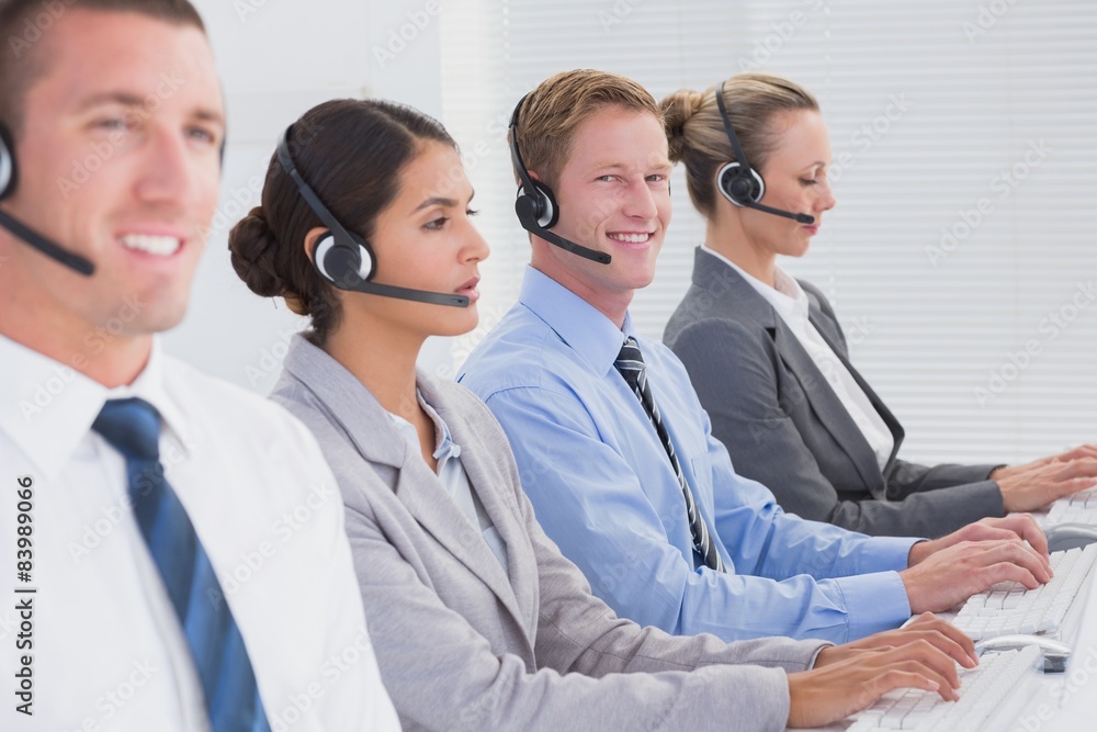 Business team working on computers and wearing headsets Business team working on computers and wearing headsets
