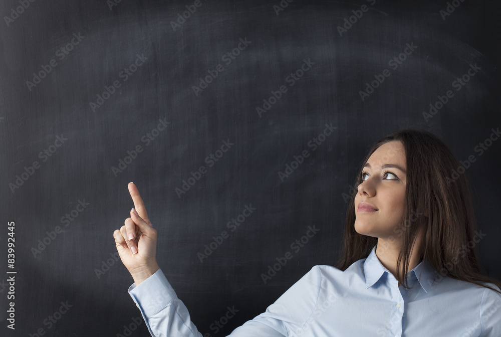 Businesswomen pointing to blank blackboard