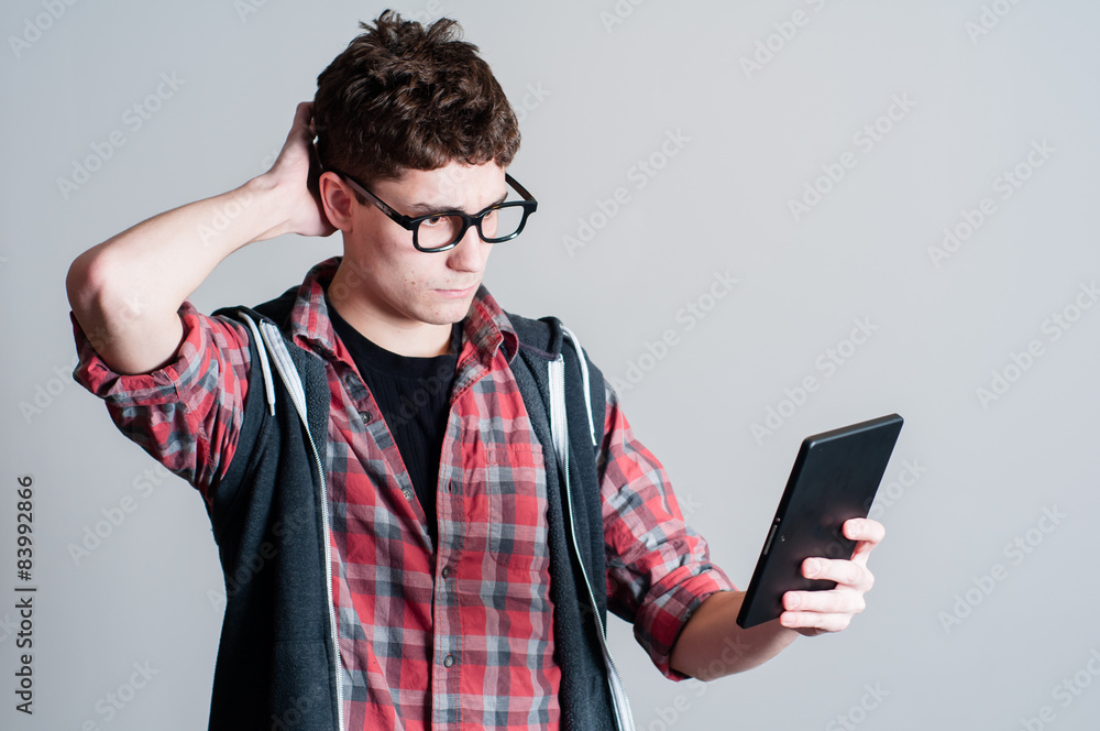 teen boy looking at a personal tablet teen boy looking at a personal tablet