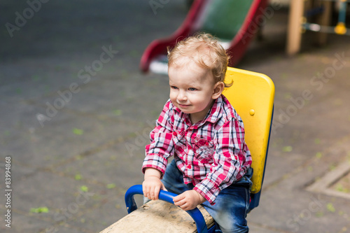 Cute baby boy on a seesaw swing