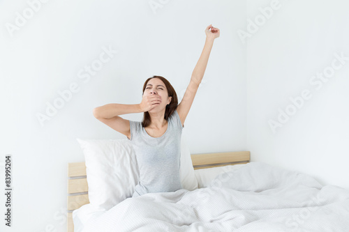 Asian woman yawning at the morning in living room