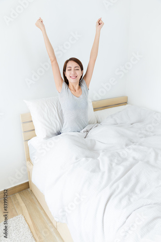 Young woman stretching her hand on bed