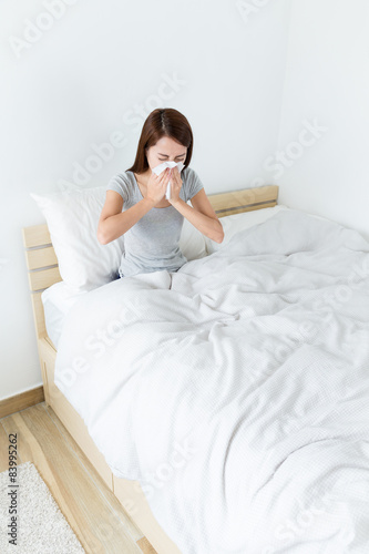 Asian woman feeling sick and sneeze at living room