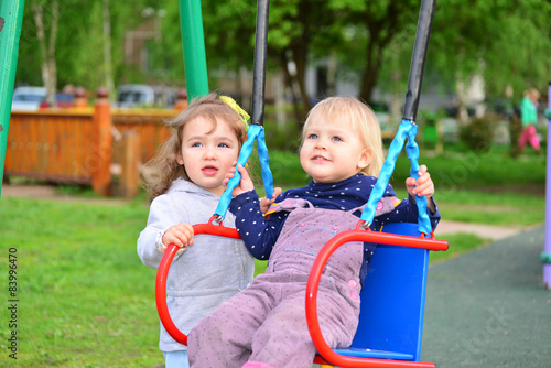 Two little girl on  swing ride © olgavolodina