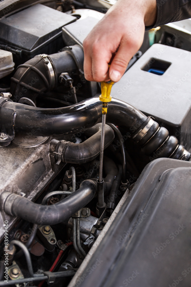 Obraz premium Mechanic checks the oil on a car being repaired