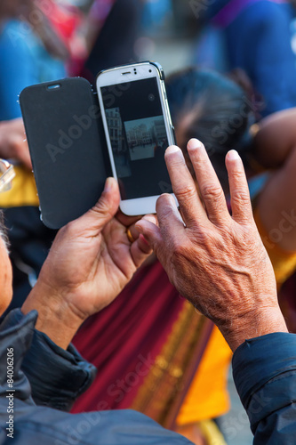 älterer Mann fotografiert mit seinem Smartphone photo