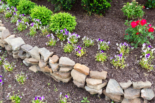 Fotografie Natural rock retaining wall in a garden