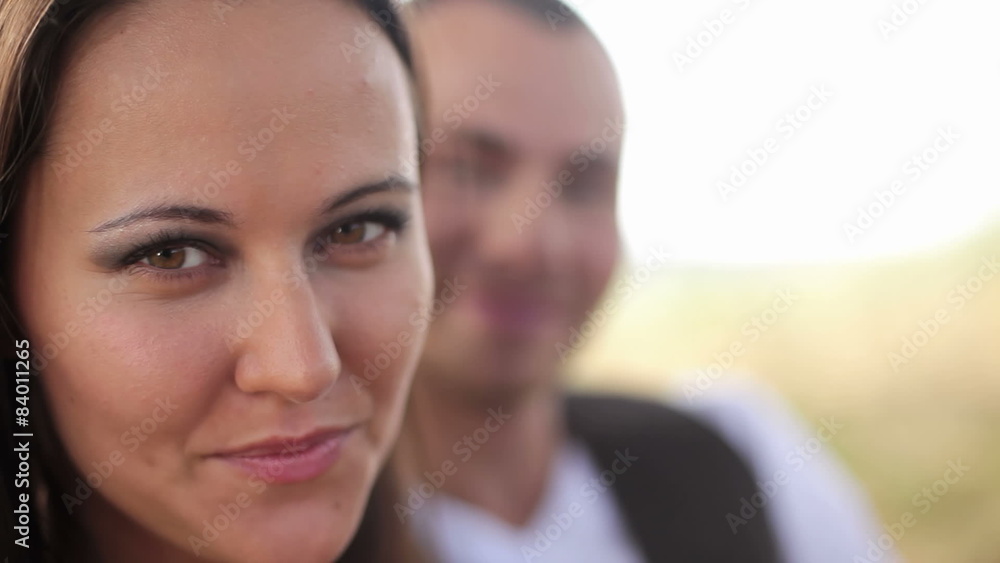 Attractive couple look and smile into the camera. Close up shot. Attractive couple look and smile into the camera. Close up shot.