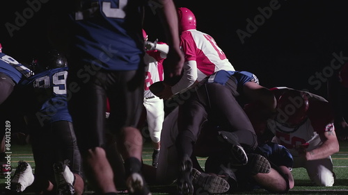 A football player gets tackled as he tries to jump over the pile for a touchdown
