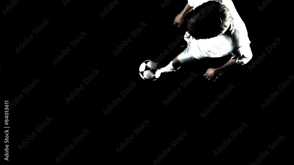 A soccer player on an artificial field pitch, juggles the ball. A soccer player on an artificial field pitch, juggles the ball.