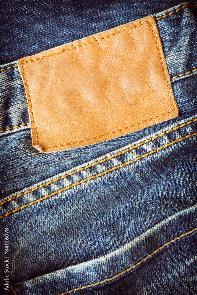 brown leather tag on blue jeans