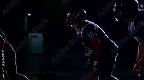 Three football defensive players lone up and get ready to blitz the quarterback
