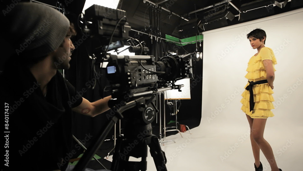 Behind the scenes of a female model being filmed by a male using a Red camera. Behind the scenes of a female model being filmed by a male using a Red camera.