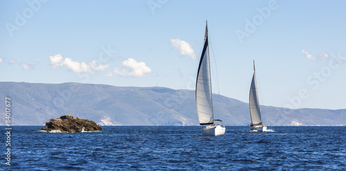 Two sailing boats yacht or sail regatta race on blue water Sea.