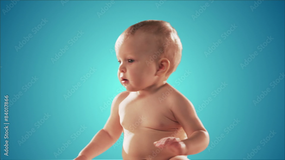 Cute baby sitting down looks around. Medium shot Cute baby sitting down looks around. Medium shot