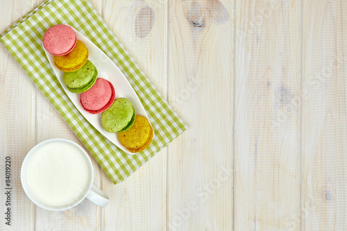Empty plate with measure tape, macarons and milk. Diet food on w