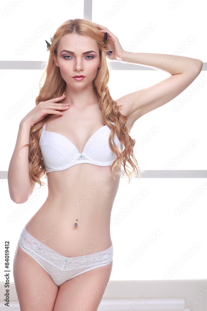 Naklejka premium Beautiful sexual blonde in a lingerie on a background a window