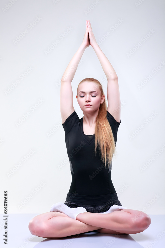 Beautiful young girl is engaged in a fitness, on a light-grey Beautiful young girl is engaged in a fitness, on a light-grey