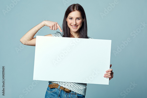 Beautiful woman standing behind, holding white blank advertising