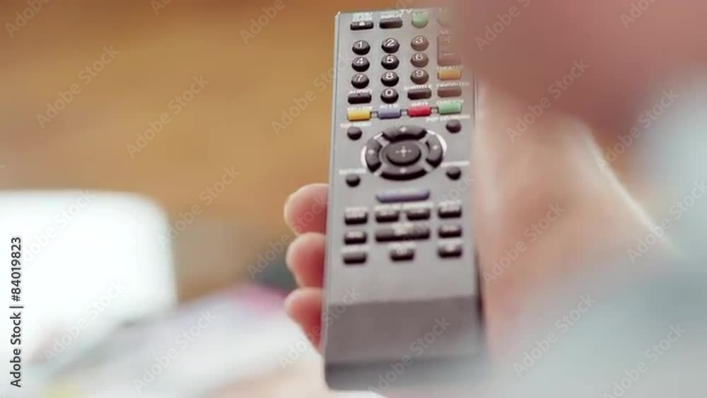 Close up of a hand operating a remote control Close up of a hand operating a remote control