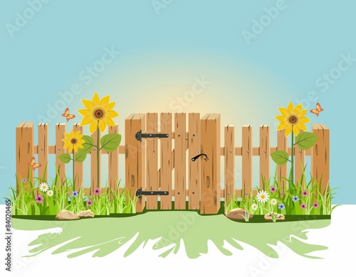 A wooden gate and fence with green grass and flowers