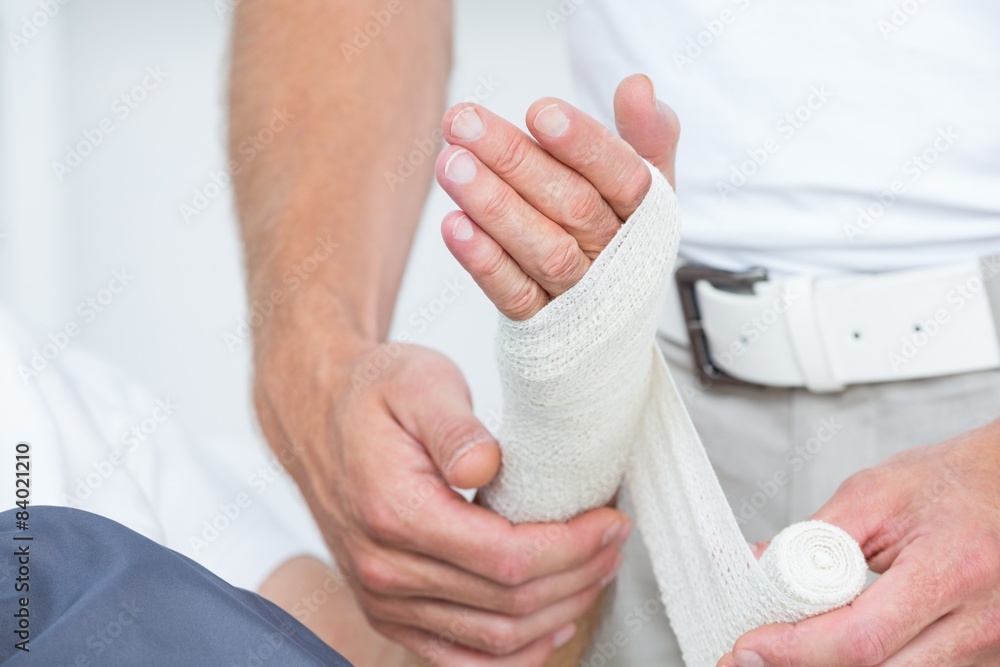 Obraz premium Doctor bandaging his patient hand