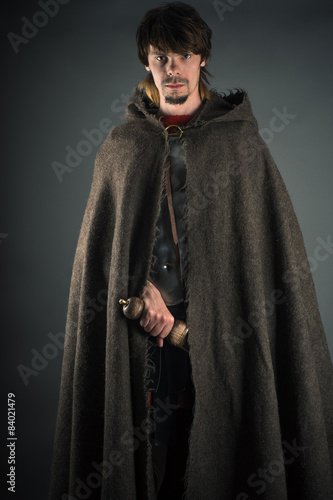 wandering man in woolen cape with a sword
