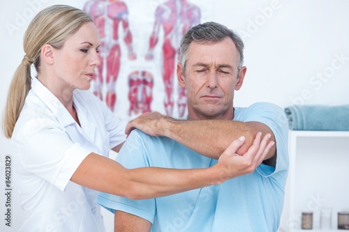 Doctor stretching a man arm