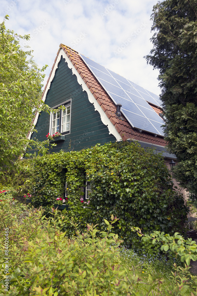 traditional dutch house with wooden front and solar panels