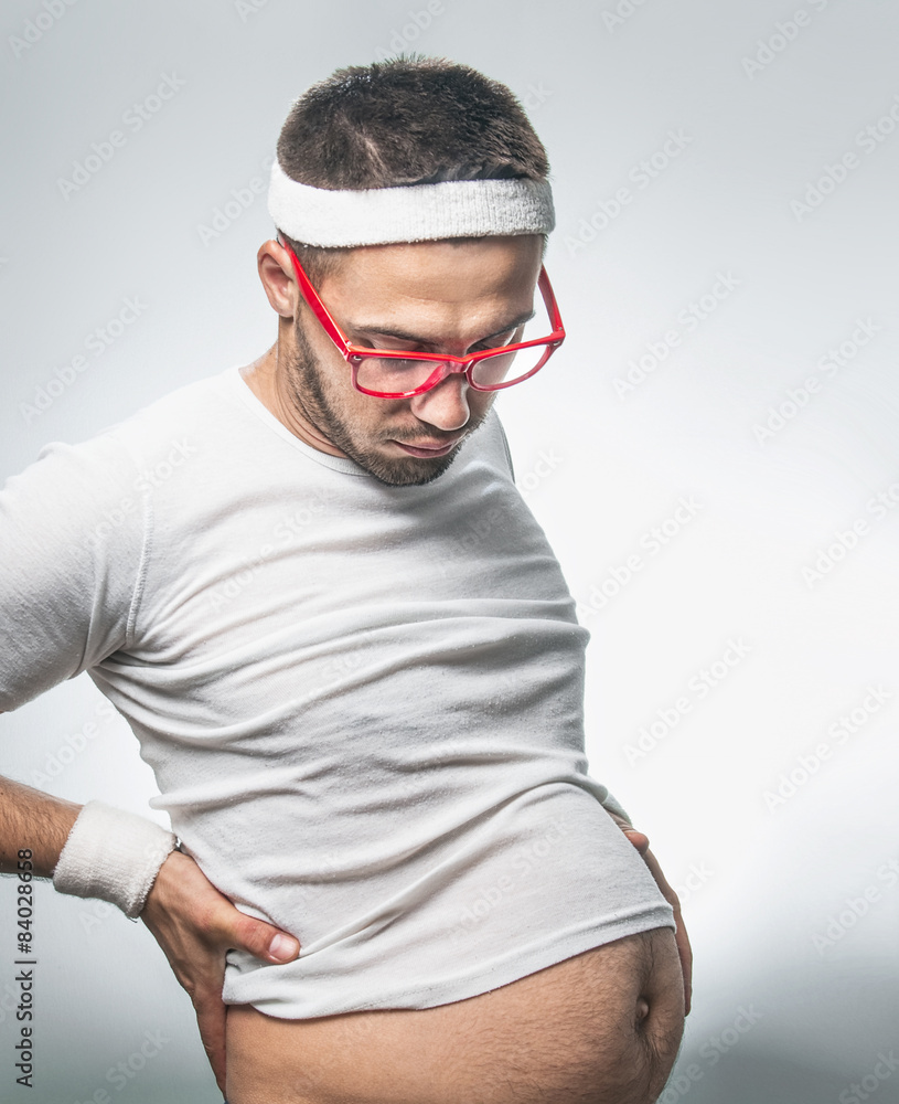 Young lazy man with a big belly isolated on gray background Stock Photo |  Adobe Stock