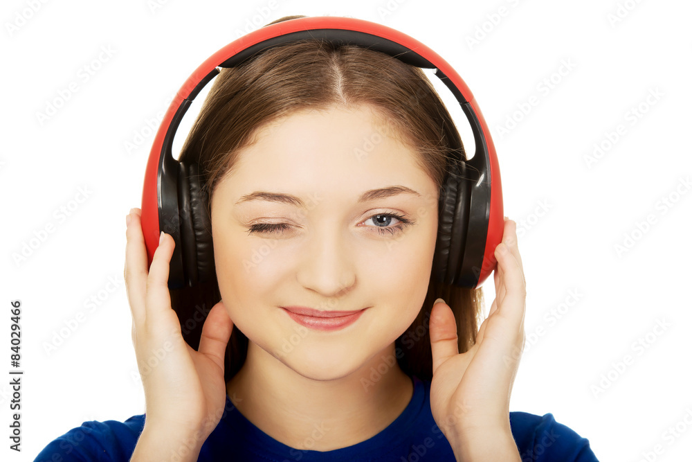 Woman with headphones blinks eye.
