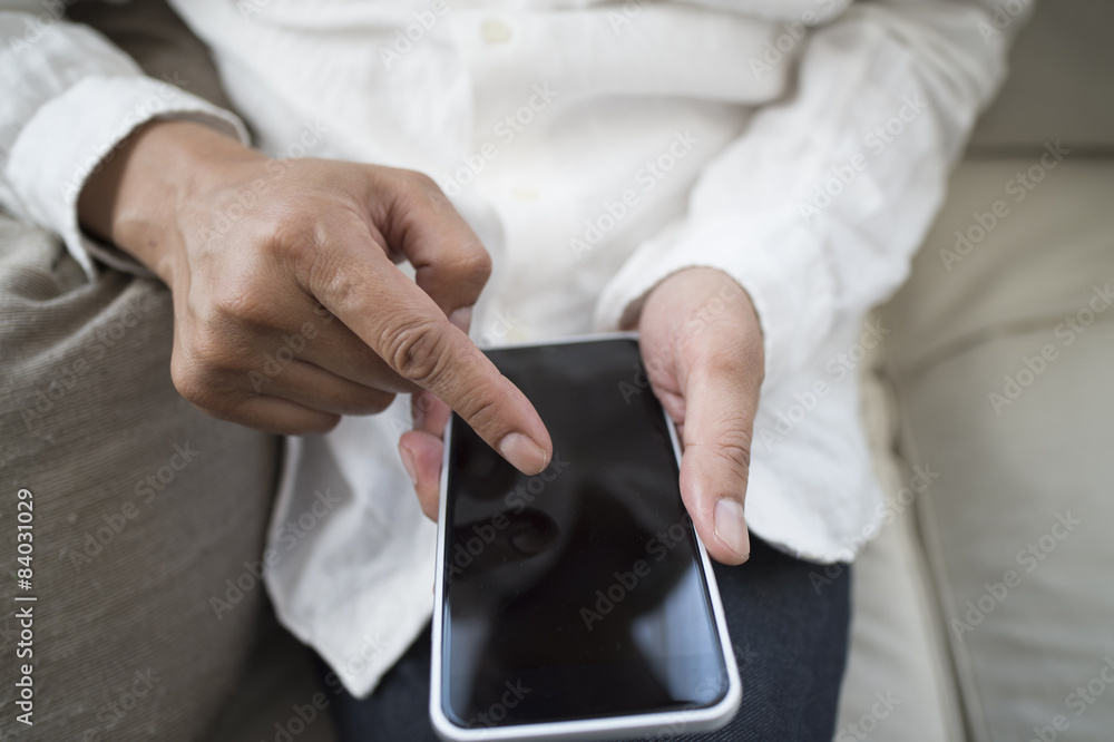 Men are using a mobile phone sitting on the sofa Men are using a mobile phone sitting on the sofa