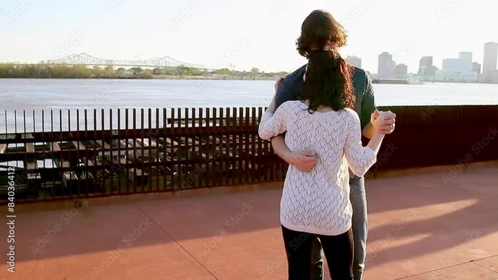Couple dance in a park overlooking a bay Couple dance in a park overlooking a bay