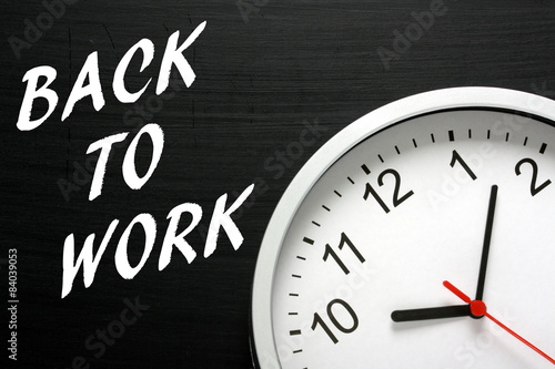 Back To Work written on a blackboard with a clock face