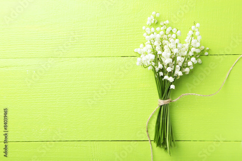 Lily of the Valley on green wooden background