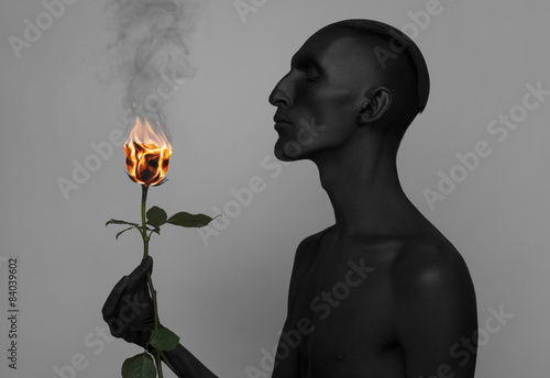 Εκτύπωση καμβά a man with black skin holding a burning rose, black death