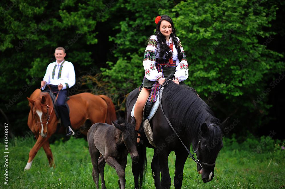 Young couple on national dress with horses Young couple on national dress with horses