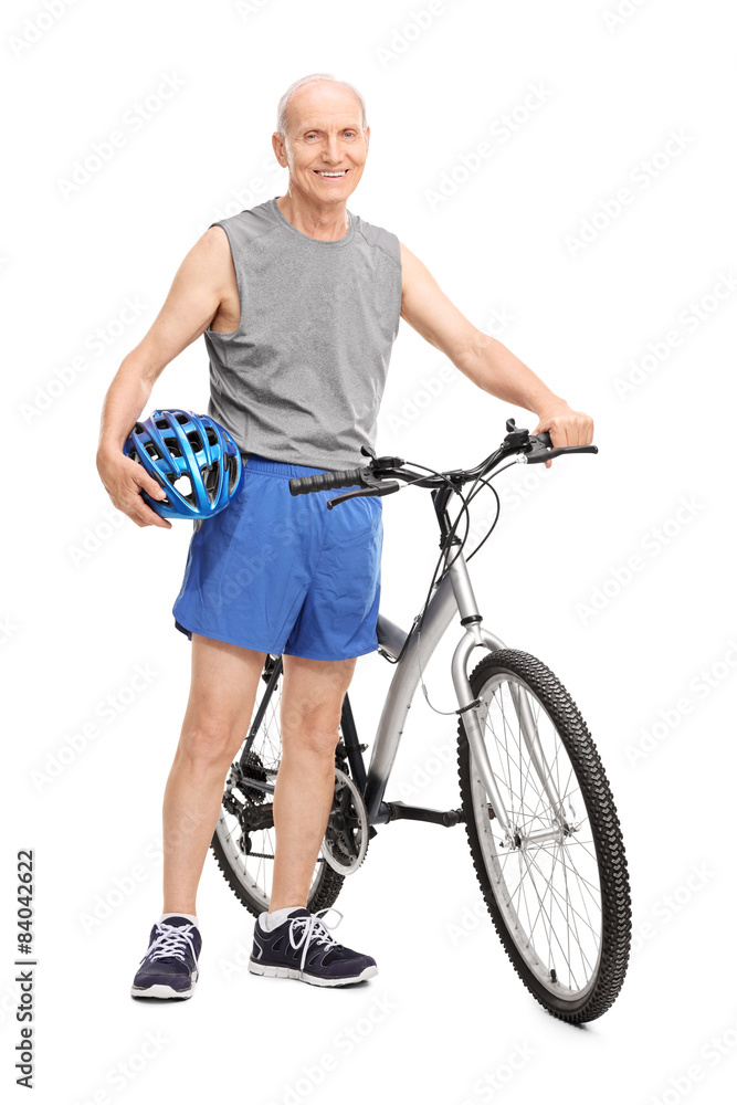 Fototapeta premium Active elderly man posing next to a bicycle