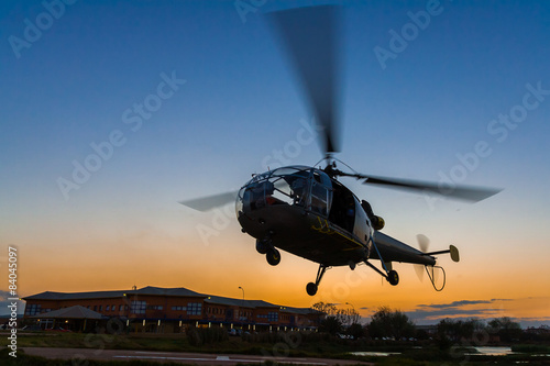 Картината върху платно Helicopter landing at sunset to the heliport