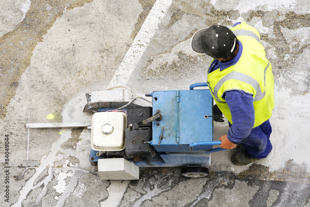 Fototapeta premium worker using cutting pavement machine in the city road