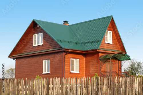 Wooden house under green metal roof