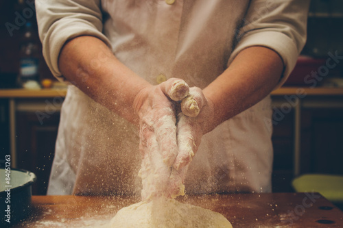 Tableau sur toile Chef applaudir mains pleines de farine sur la pâte fraîche